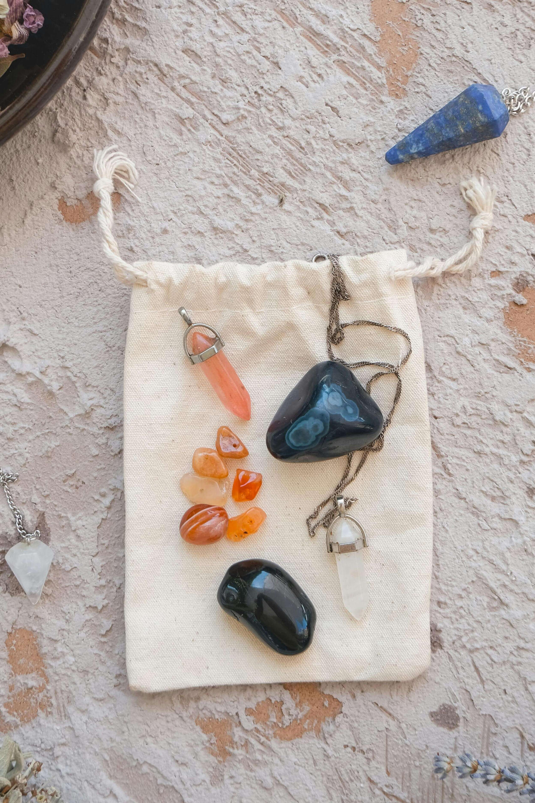 Crystals to manifest Photo of some crystals, crystal pendulums on a cloth bag.